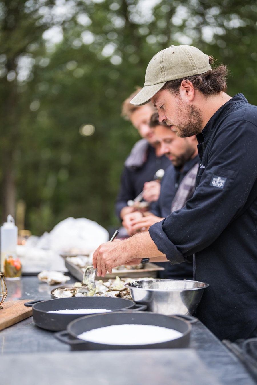 Lucas Lefebure opent oesters aan een buitenkeuken